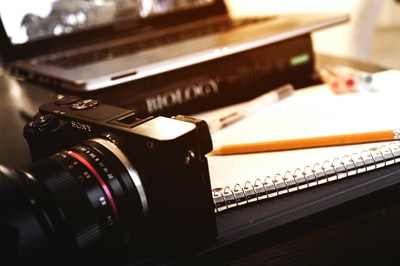 索尼紧凑型相机靠近open spring笔记本和铅笔